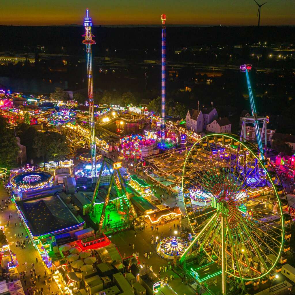 „Wir hatten elf Tage lang eine sehr schöne und familiäre Atmosphäre inklusive Urlaubsfeeling mit einem guten Besuch.“ So bewerteten am Sonntagmittag (16. August) die Veranstalter die Cranger Kirmes 2026. Knapp zwölf Stunden vor dem Ende des größten Volksfestes in NRW sagte Kirmesdezernent Dr. Frank Burbulla: „Es war ein fröhliches und friedliches Volksfest. Kommen heute noch einmal über 400.000 Besucher, liegen wir in der Gesamtbesucherzahl nach elf Kirmestagen bei etwa 3,9 Mio. Besucherinnen und Besucher.“ Das für Sonntagabend geplante Höhenfeuerwerk zum Abschluss der Kirmes wurde gegen 14 Uhr wegen der anhaltenden Trockenheit und der damit einhergehenden Brandgefahr abgesagt.